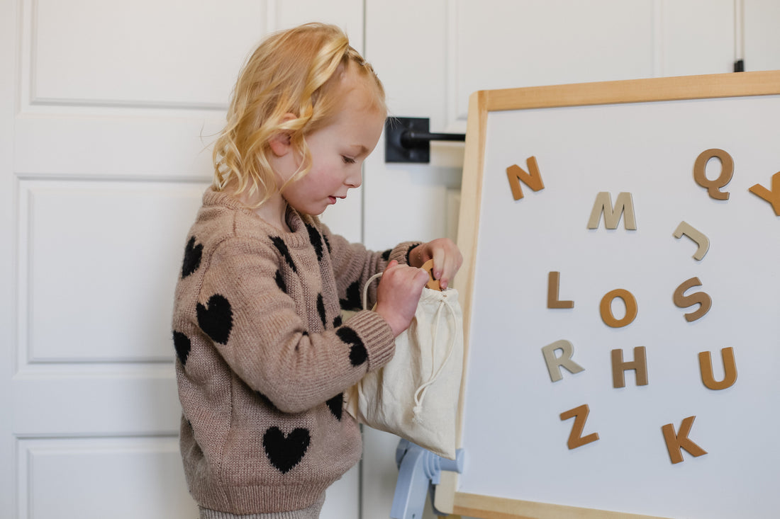 gale tots for kids little girl learning with magnetic letters in a whiteboard